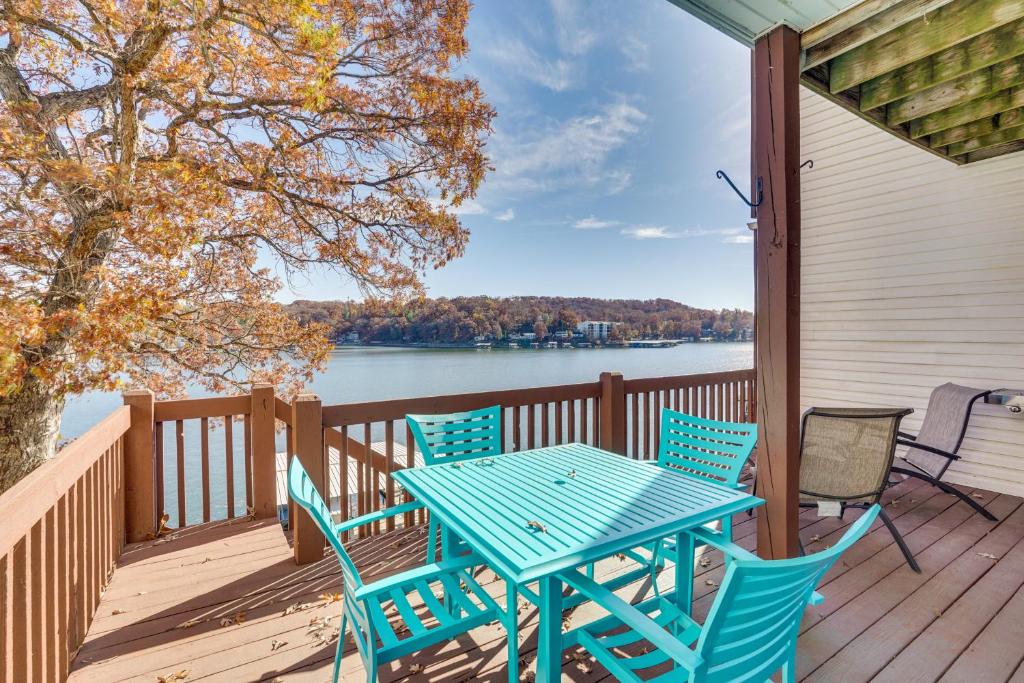 einen Tisch und Stühle auf einer Terrasse mit Blick auf das Wasser in der Unterkunft Lake of the Ozarks Vacation Rental Boat DockandSlip in Lake Ozark