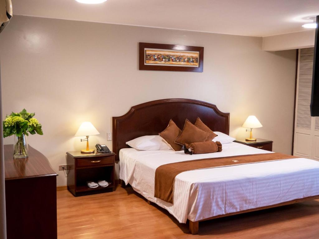 1 dormitorio con 1 cama grande y 2 mesitas de noche en Hotel Britania San Borja, en Lima