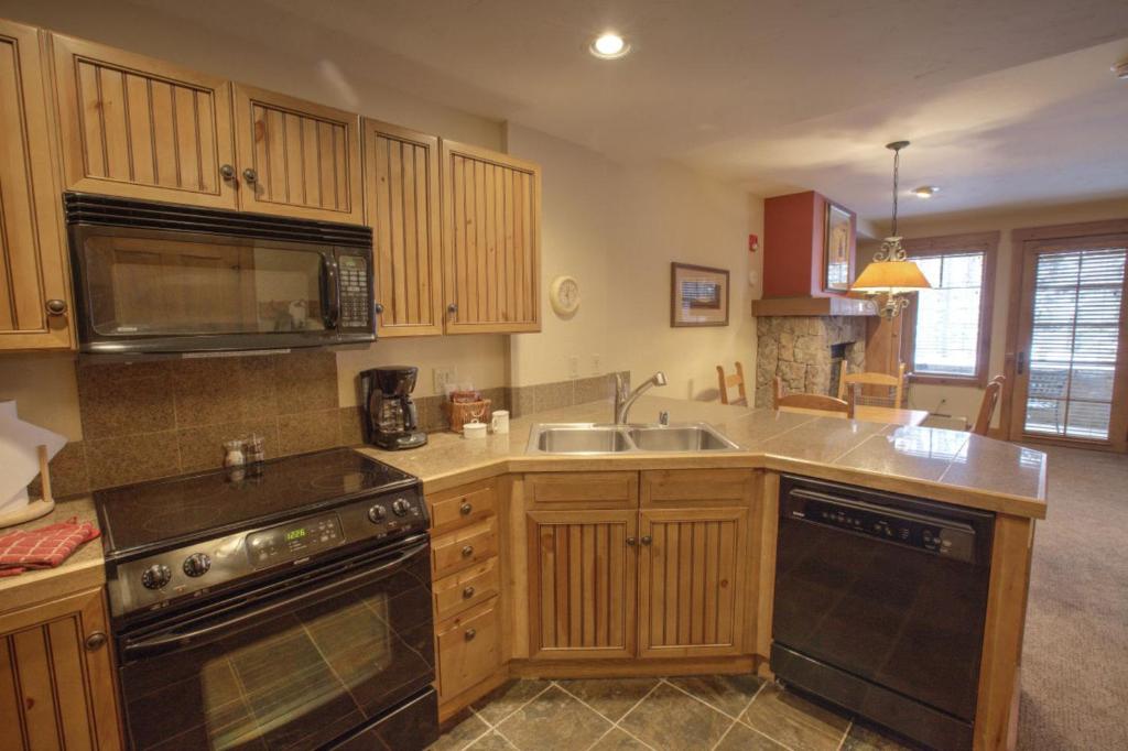 uma cozinha com um lavatório e um fogão forno superior em Mountain Thunder Lodge em Breckenridge