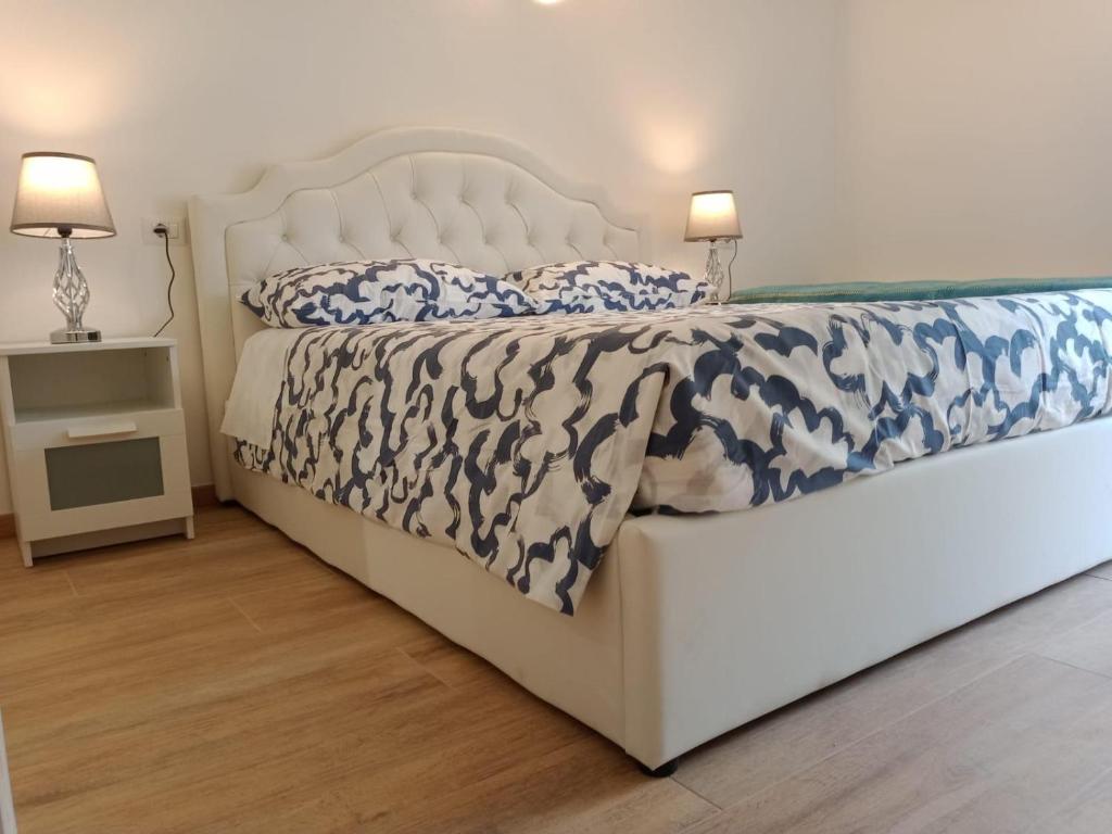 a bedroom with a white bed with blue and white comforter at La Grotta Sardegna 5 Bedrooms each with a Private Ensuite Bathroom featuring a Hydromassage Shower Air Conditioning in Urzulei
