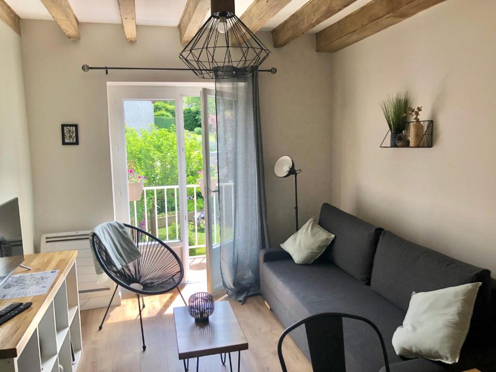 een woonkamer met een bank en een tafel bij VerOliv : Superbe appartement rénové proche du centre-ville in Le Creusot