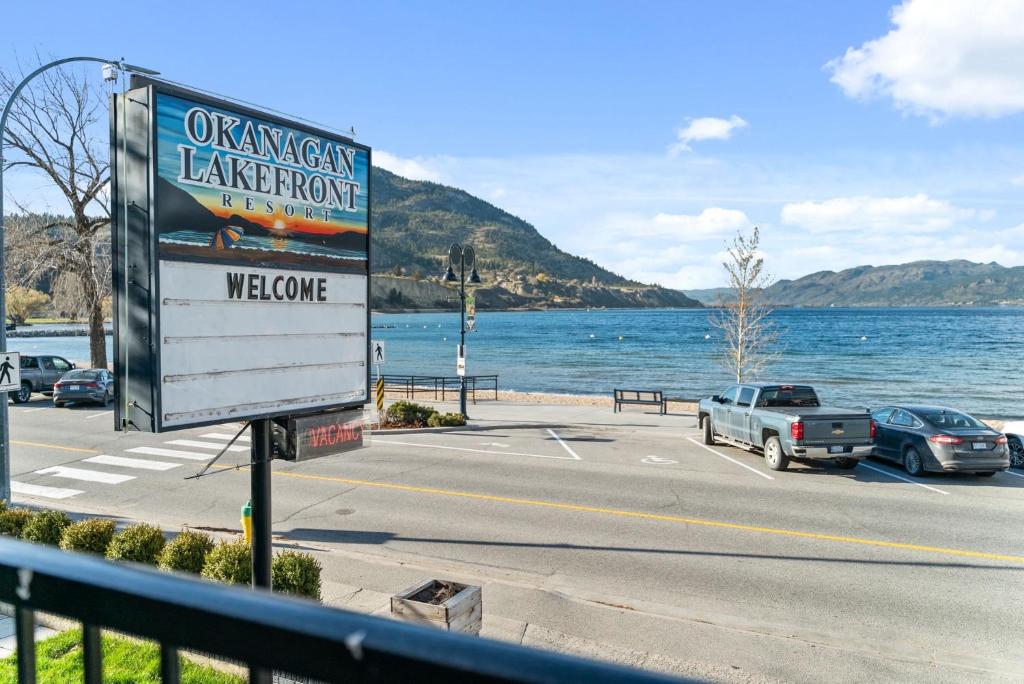 a sign on the side of a road next to a lake at Okanagan Lakefront Resort in Penticton