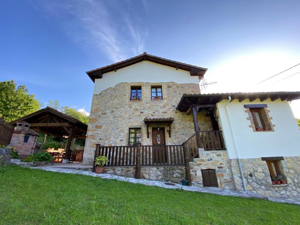 una gran casa de piedra con una valla en un patio en Apartamentos Rurales La Caviana, en Cangas de Onís