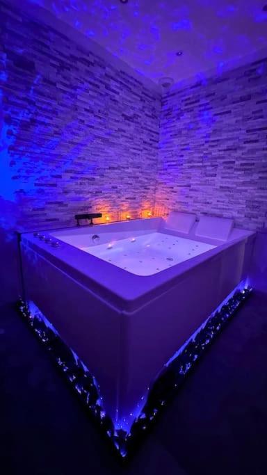 Cette chambre dispose d'une grande baignoire et d'un mur en briques. dans l'établissement La suite EverBlue, à Saintry-sur-Seine