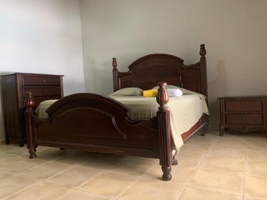 - un lit avec un cadre en bois dans une chambre dans l'établissement VILLA GUAVABERRY n, à Paraíso