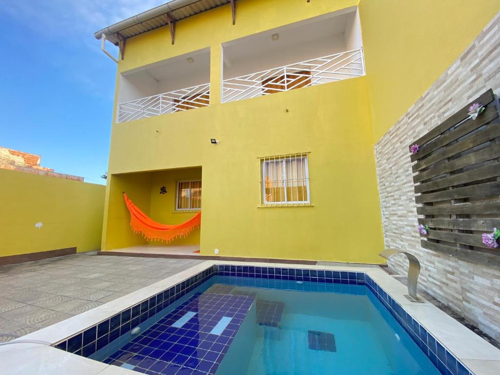 a yellow house with a swimming pool in front of it at Linda Casa com piscina Brisa do Mar - Maragogi in Maragogi