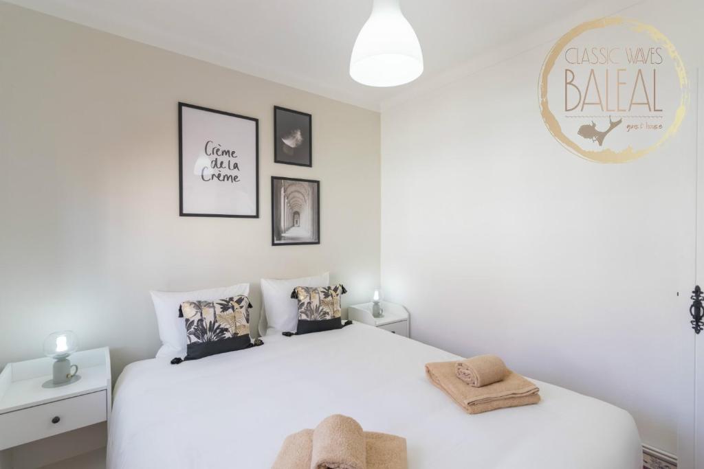 a white bedroom with a large white bed with pillows at Baleal Classic Waves Guest House in Baleal