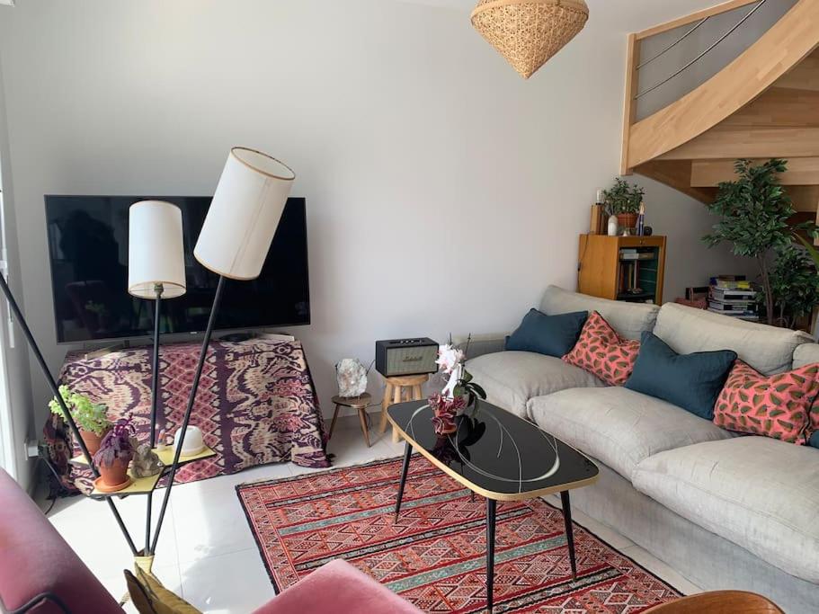 un salon avec un canapé et une table dans l'établissement Maison des mésanges, à Colmar