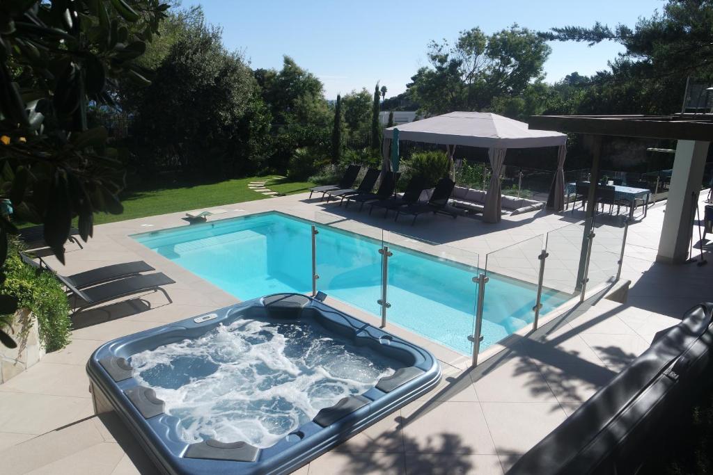 a swimming pool with a hot tub on a patio at Villa Perle De La Mer in Saint-Aygulf