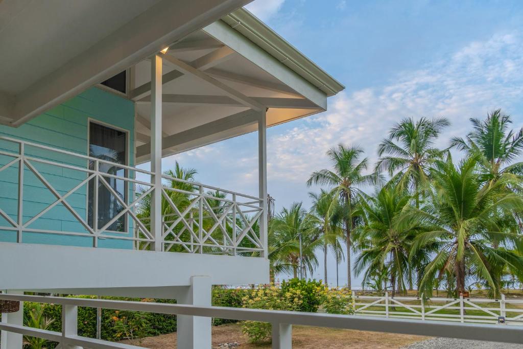 a building with palm trees in the background at Casa Choucoune in Parrita
