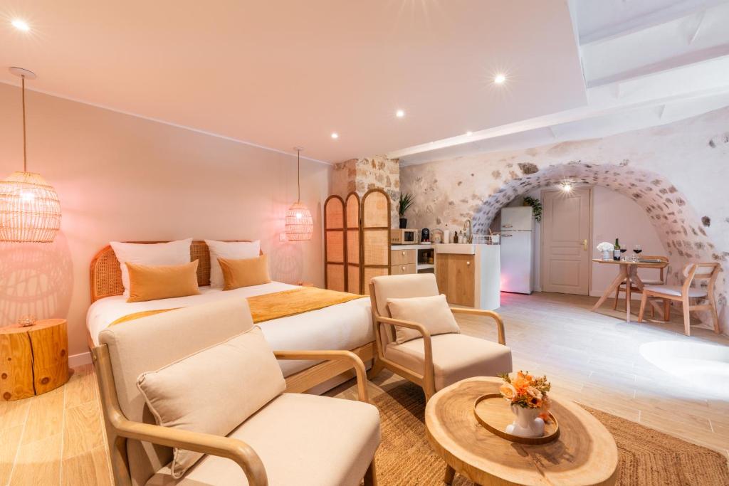 a bedroom with a bed and a table and chairs at La Parenthèse Grassoise-Votre échappée romantique in Grasse