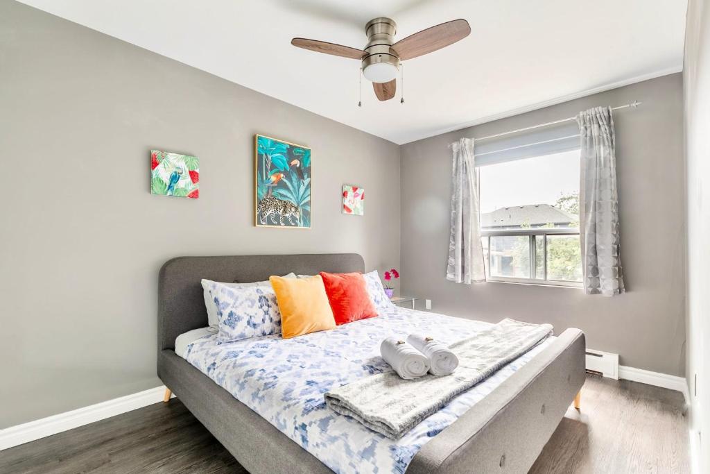 a bedroom with a bed with colorful pillows and a window at Modern 2BR - King Bed Apartment - PRIME Location in Hamilton