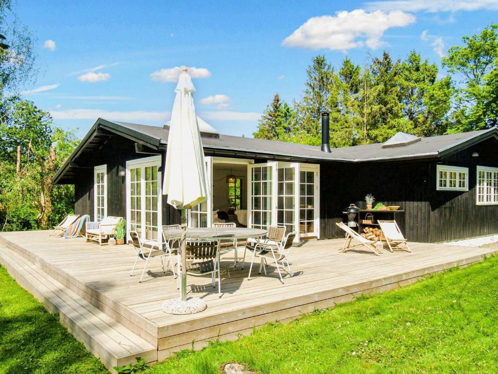 Casa con terraza con mesa y sombrilla en Holiday home Vejby XXXVIII en Vejby