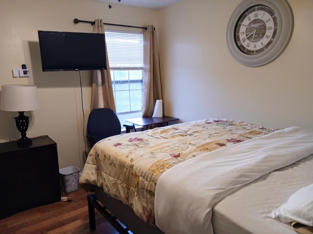 een slaapkamer met een bed en een klok aan de muur bij Cozy private rooms in Jonesboro