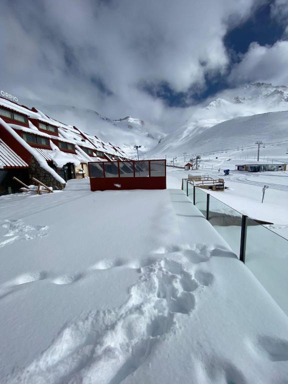 a snow covered roof of a house with footprints in the snow at Rodas - Las Leñas in Las Lenas
