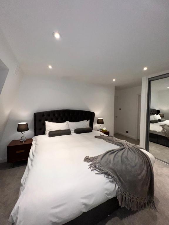 倫敦的住宿－Mayfair Piccadilly Apartment 5，卧室配有一张白色大床和镜子