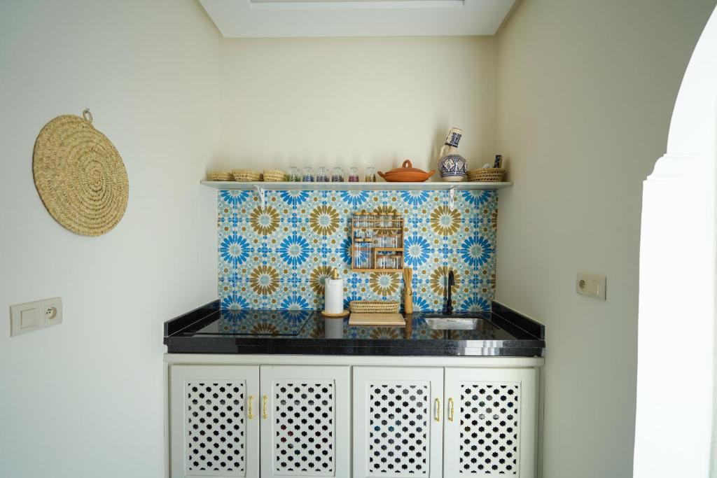 a kitchen with a counter with a tile on the wall at Dar Badr in Tangier