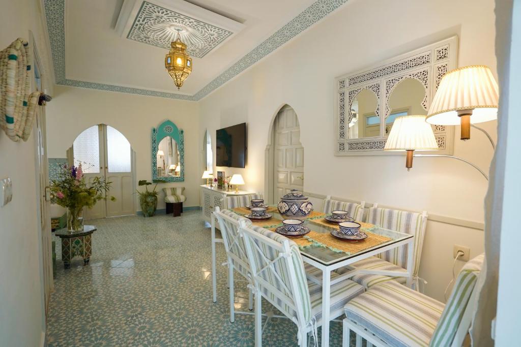 a white dining room with a table and chairs at Dar Badr in Tangier