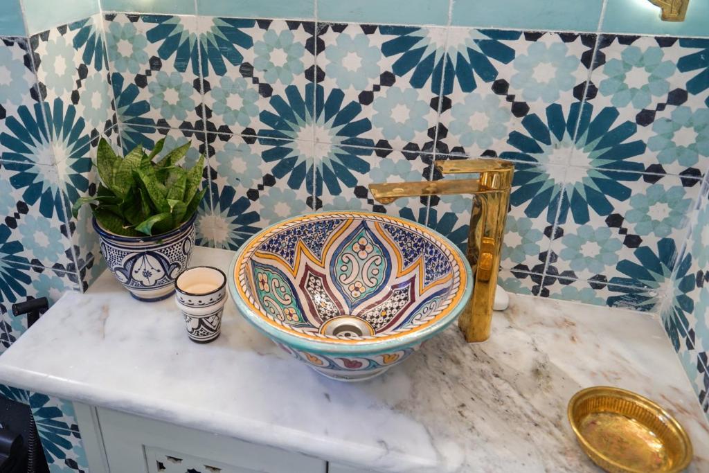 a bathroom with a sink on a counter with blue and white tiles at Dar Badr in Tangier
