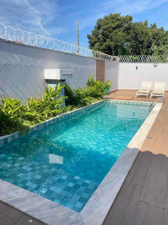 uma piscina com água azul num quintal em Aconchego! Sua casa com Piscina em Passos!! em Passos