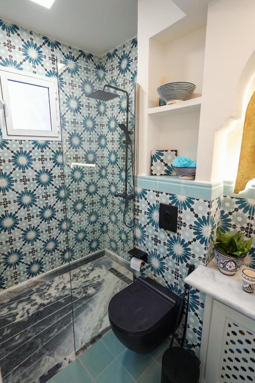 a bathroom with a shower with a black toilet at Dar Badr in Tangier