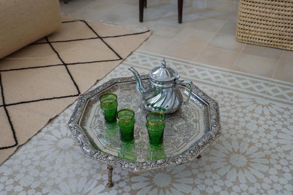 a glass tray with four green glasses and a teapot at Dar Badr in Tangier