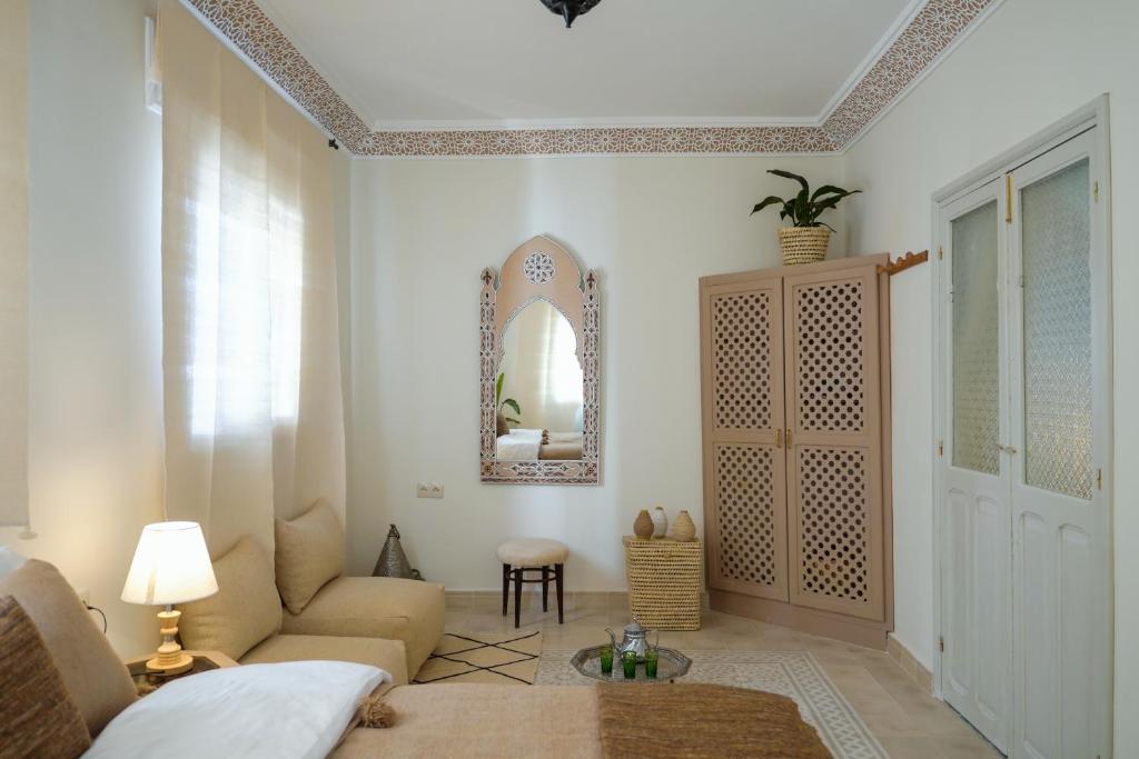 a living room with a couch and a mirror at Dar Badr in Tangier