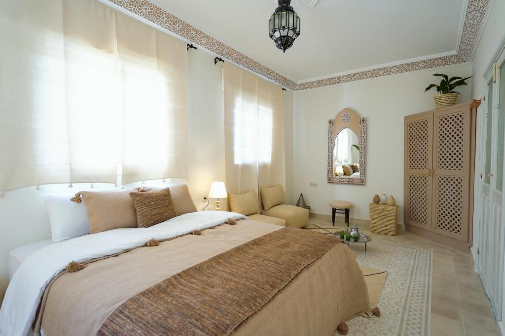 a bedroom with a large bed and a couch at Dar Badr in Tangier