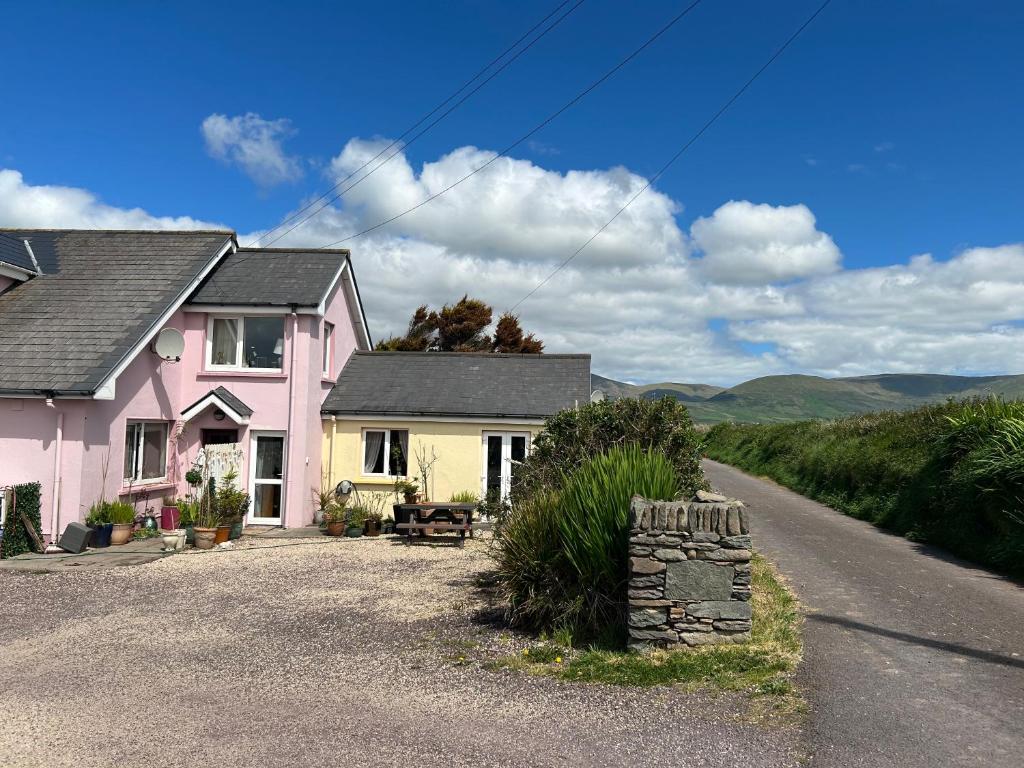 a pink and yellow house on the side of a road at Tig Monbretia in Dingle