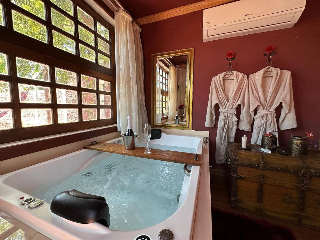 een badkamer met een bad en een spiegel bij Divina Cabana - Lago Corumbá IV - Alexânia in Alexânia