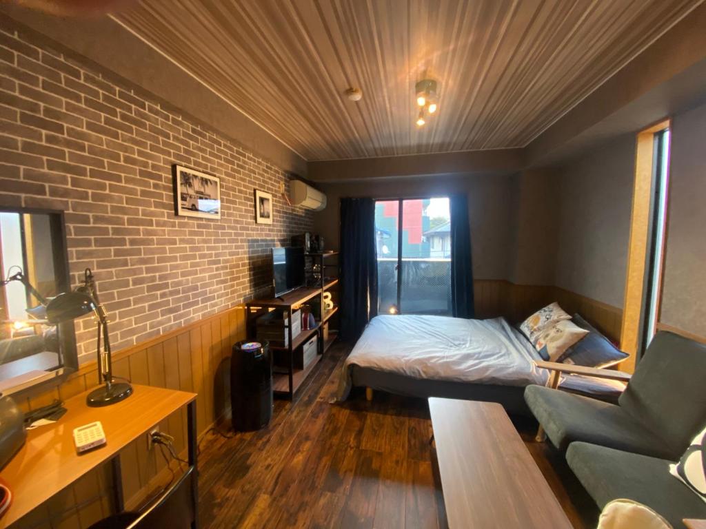 岐阜市にあるVacanza Resortのベッド1台とソファが備わる小さな客室です。
