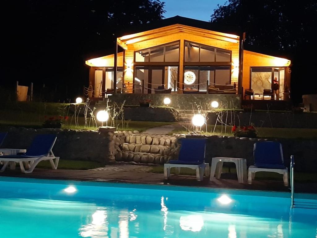 een huis met twee blauwe stoelen en een zwembad bij Balada dintre dealuri, Sibiu, Cisnadioara in Cisnadioara