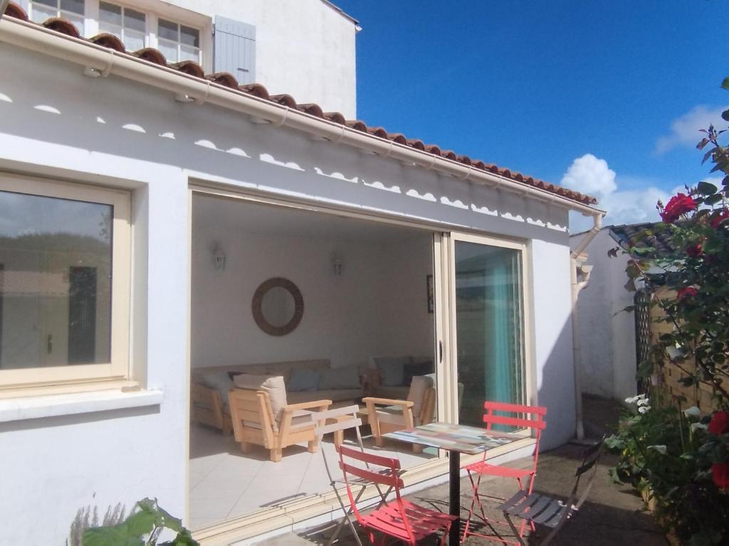 un patio avec une table et des chaises sur un balcon dans l'établissement Grande maison familiale, 9 pers., à 1800m de la plage, avec terrasses, clim, et équipements complets - FR-1-778-19, à Saint-Georges-dʼOléron