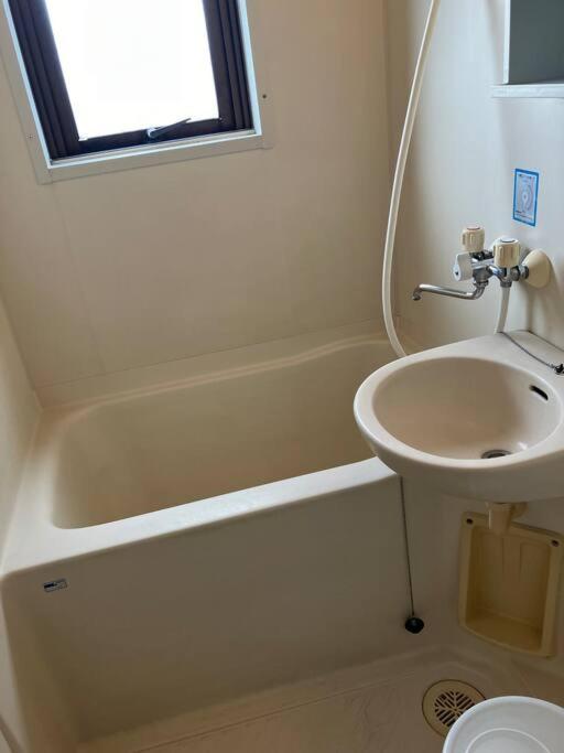 un bagno con un lavandino, una vasca da bagno e un lavandino di メゾンジョイ久須志#305 ad Aomori