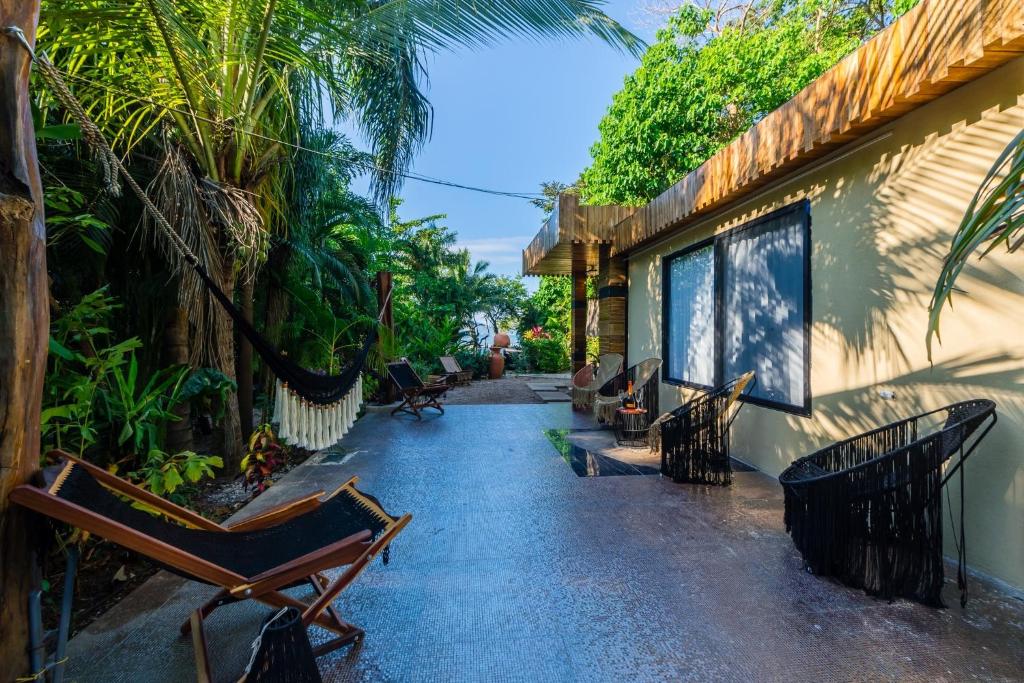 un patio con sillas y una casa en Ocho Artisan Bungalows, en Tamarindo