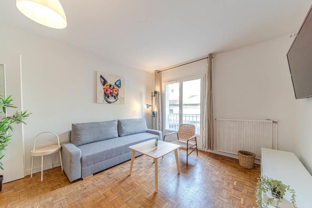 un salon avec un canapé bleu et une table dans l'établissement Le Jardin d’Alexandre cosy 4 pers Charpennes, à Villeurbanne