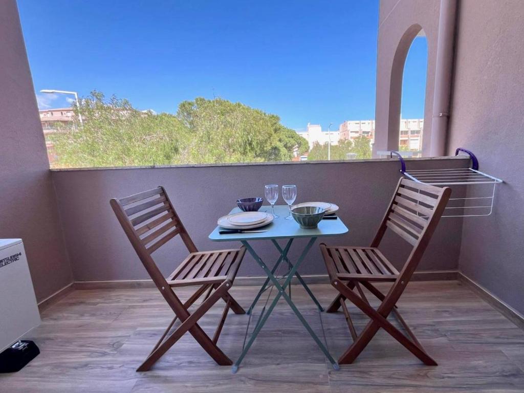 une table et deux chaises sur un balcon dans l'établissement Studio cosy à Cavalaire avec climatisation et parking - FR-1-226B-200, à Cavalaire-sur-Mer