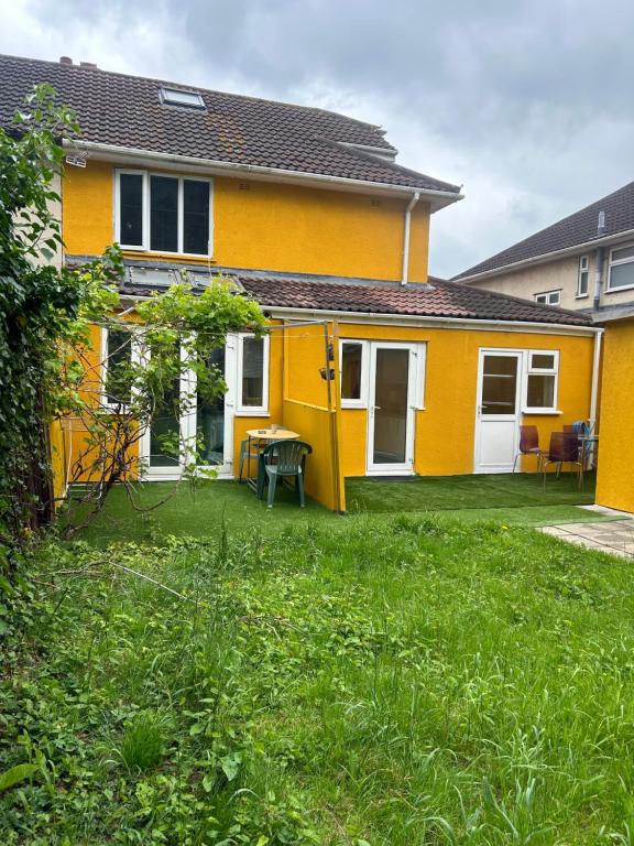 a yellow house with a lawn in front of it at Blissful 1-bedroom entire place in Cambridge