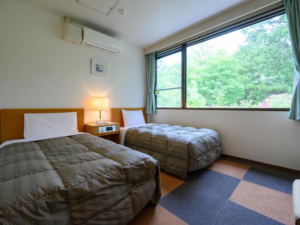 Postel nebo postele na pokoji v ubytování Rest Inn Taga