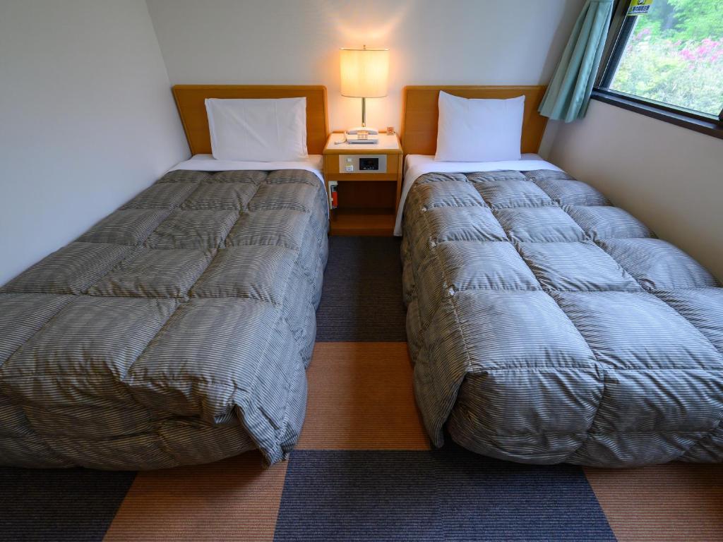 Postel nebo postele na pokoji v ubytování Rest Inn Taga