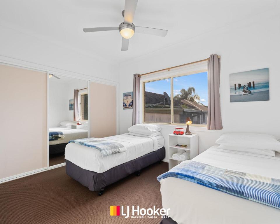 a bedroom with two beds and a window at The Moorings in Iluka