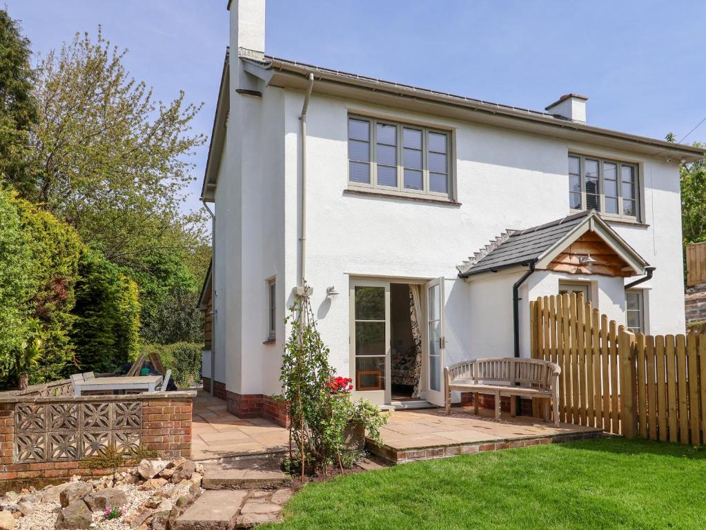 a white house with a wooden fence at Questant Lodge in Sidmouth