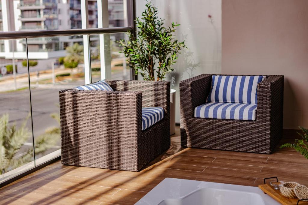 2 sedie in vimini sedute su un balcone di 2 Bed In Raha Lofts Hosted By Voyage a Abu Dhabi