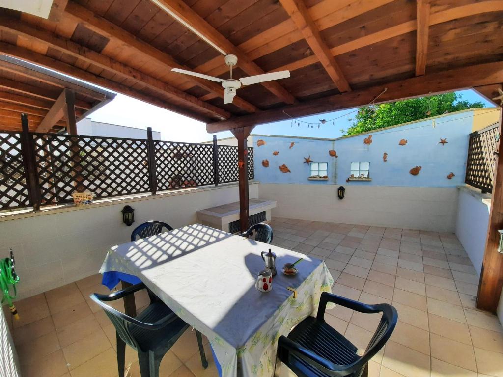 una mesa y sillas en un patio con techo en LaCasaDeiGechiOtranto, en Casamassella