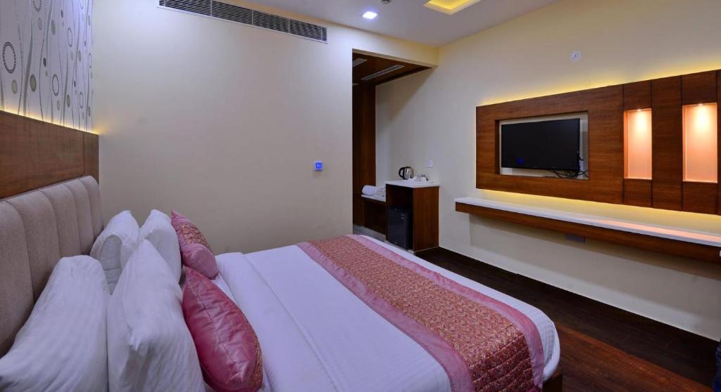 a hotel room with a bed and a tv at Hotel Smart Plaza Delhi Airport in New Delhi