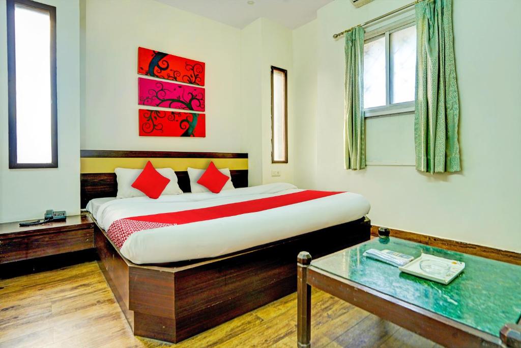 1 dormitorio con cama y mesa de cristal en Super OYO Hotel Sunshin Deluxe, en Nagpur