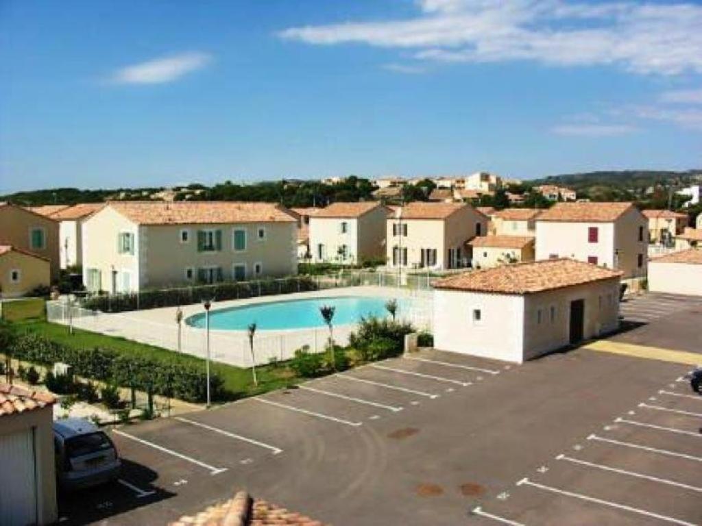 - une vue sur un parking avec une piscine dans l'établissement Appartement de vacances tout confort, à Narbonne-Plage