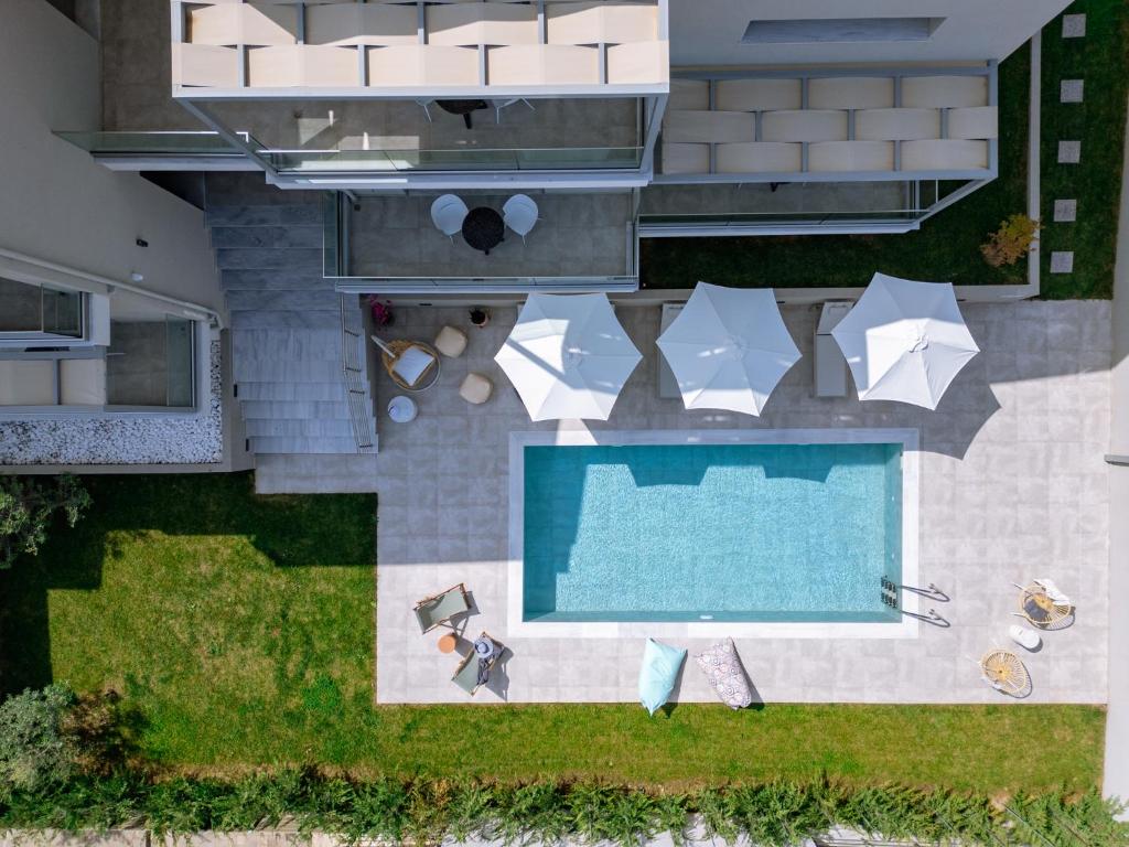 uma vista superior para uma piscina com cadeiras e guarda-sóis em Arodo Suites em Iraklitsa