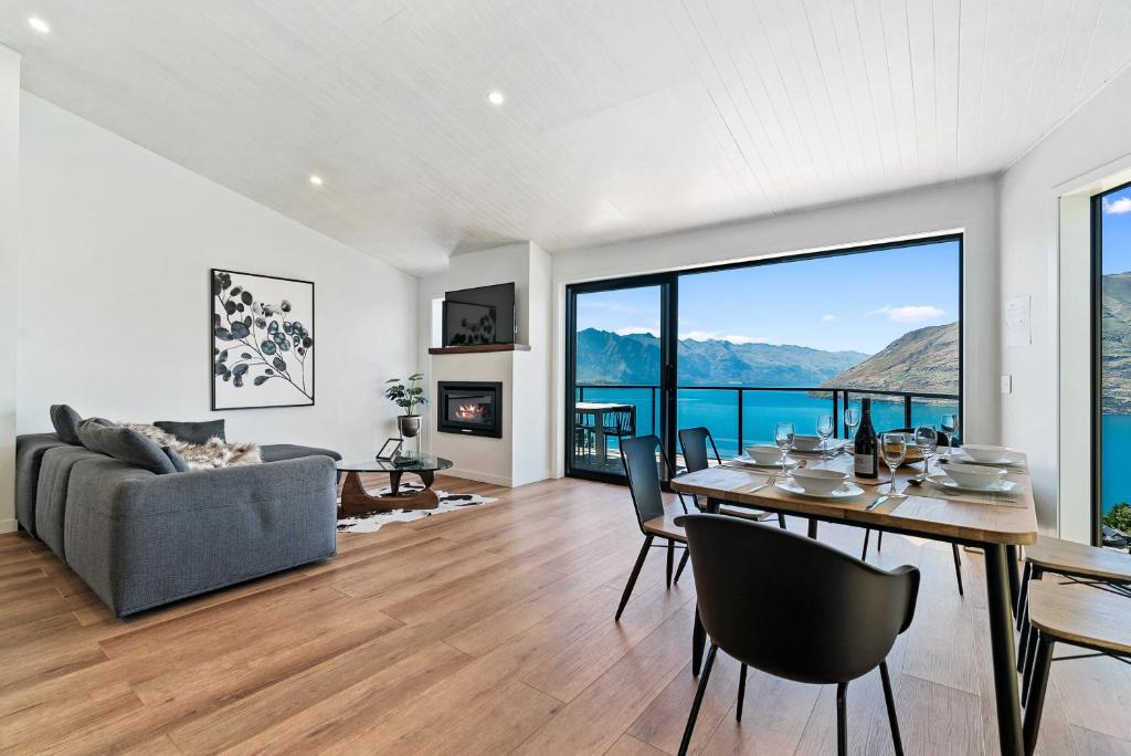 Un comedor y una sala de estar con mesa y sillas. en Modern Luxe House with Magnificent View, en Queenstown