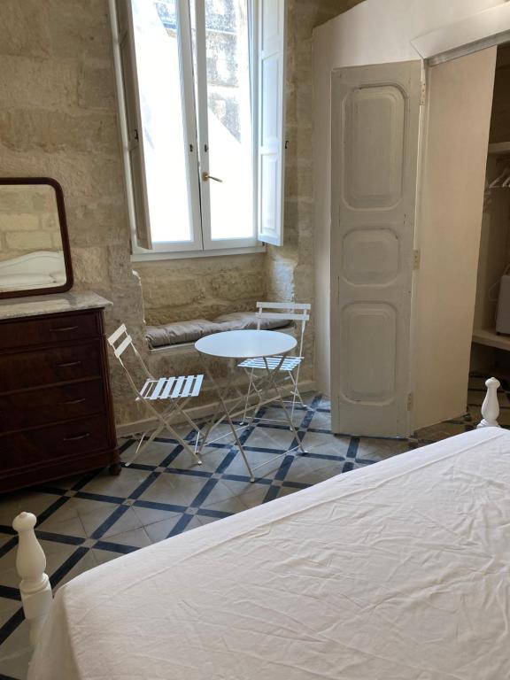 Un dormitorio con una cama y una mesa y una ventana. en Antica casa, en Vernole
